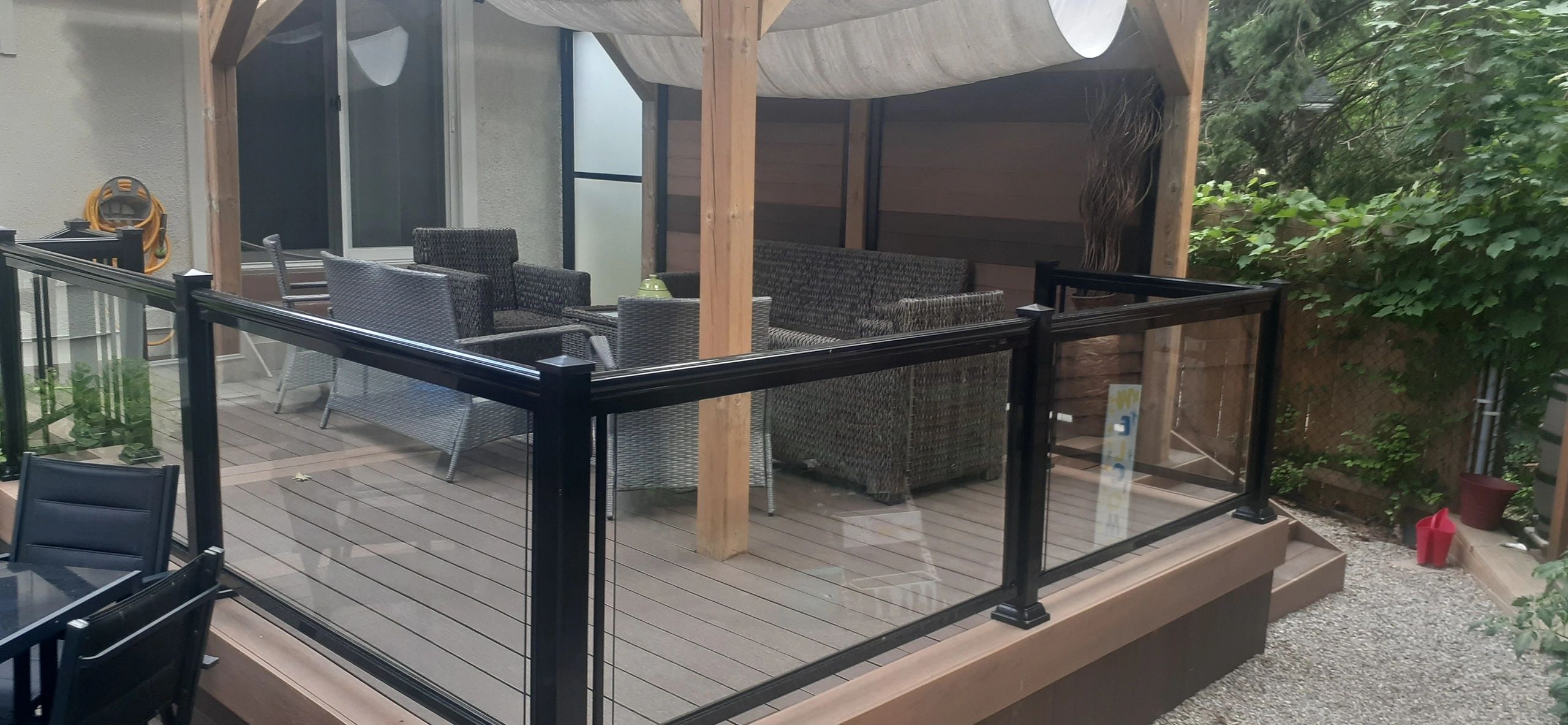 Composite deck with glass railing under a shade canopy